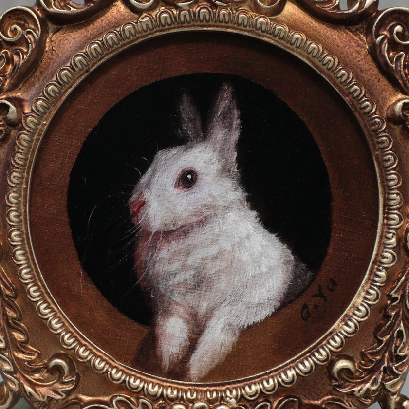 Close-up of framed bunny art print in round Baroque gilt frame