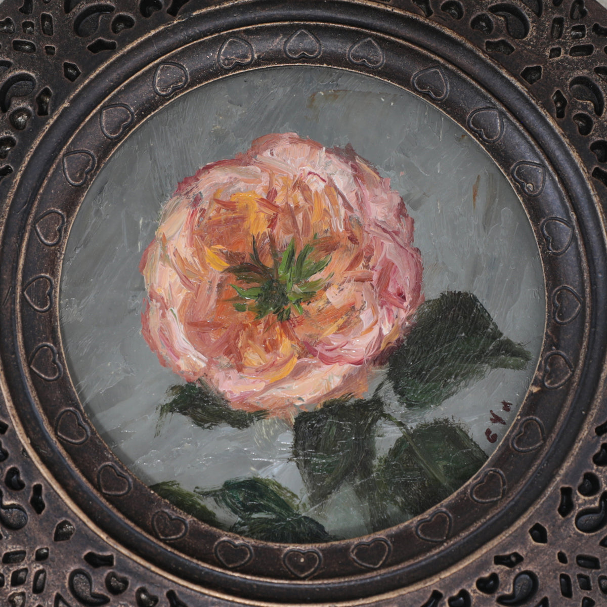 Close up of the Pink rose miniature oil painting in scalloped round frame on cream fabric