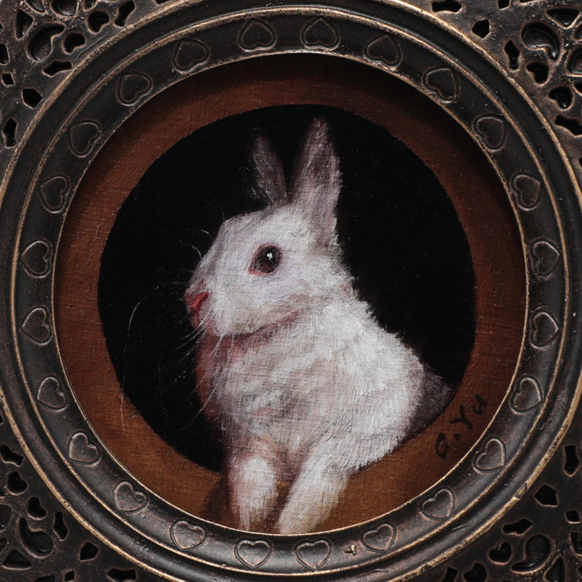 Close-up of white bunny painting print in ornate bronze gilt frame