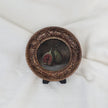 Overhead view of fig still life painting in round gilt frame, zoomed out