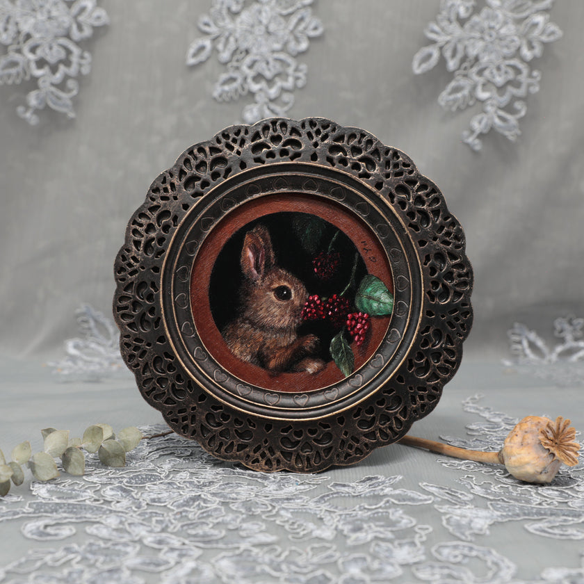 Framed bunny art print in ornate bronze frame standing, front view