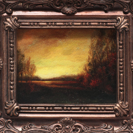Close-up of Framed sunset landscape art print on beige background with title text