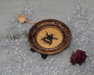 Overhead view of framed bumblebee print with dried rose and poppy pod