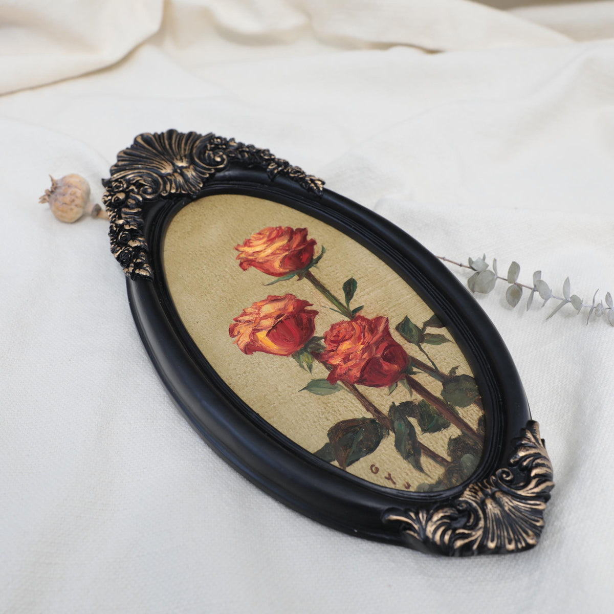 Another side view, of original red roses oil painting in an ornate long oval gilt frame on cream linen