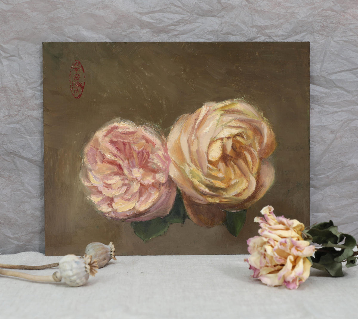 Original rose oil painting standing against a wall with dried flowers for scale. 
