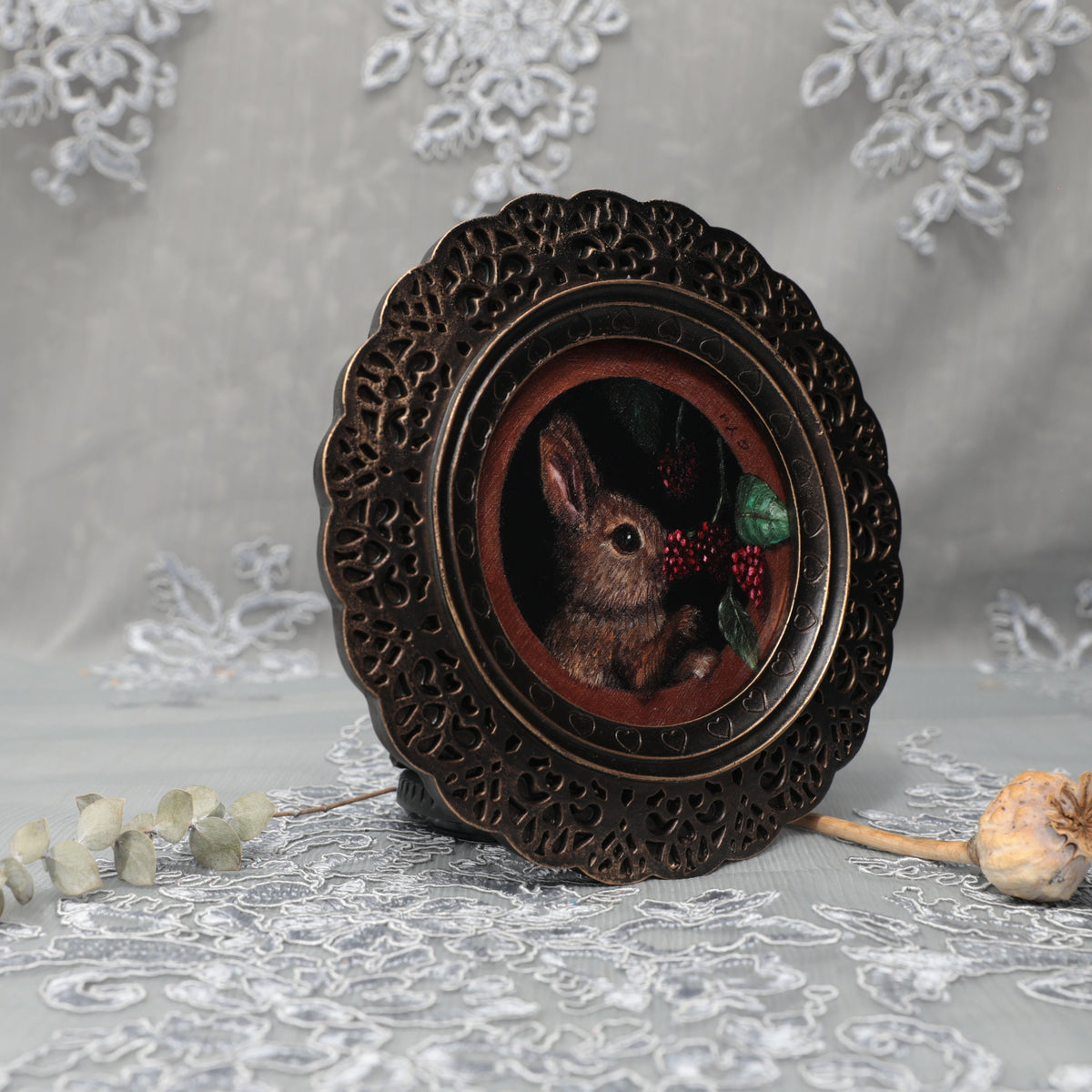 Framed bunny art print in ornate bronze frame standing, side view