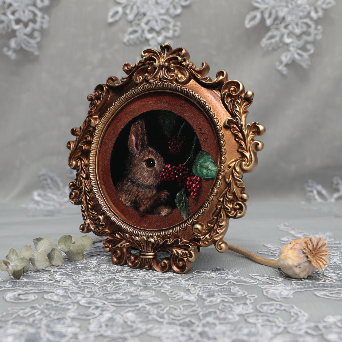 Framed bunny art print in ornate gilt vintaged frame, side view