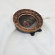 Side view of fig still life painting in round gilt frame, zoomed out