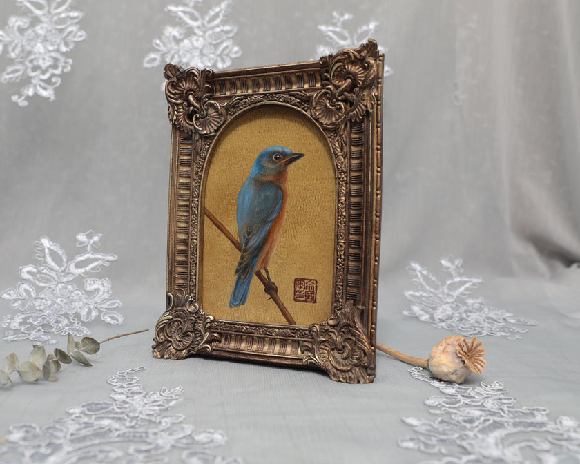 Side angle of arch-top bronze frame showing bluebird painting print