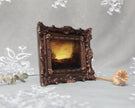 Side view of framed sunset landscape print in carved bronze frame