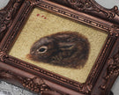 Small framed Cottontail Rabbit painting print in ornate frame, top view close-up