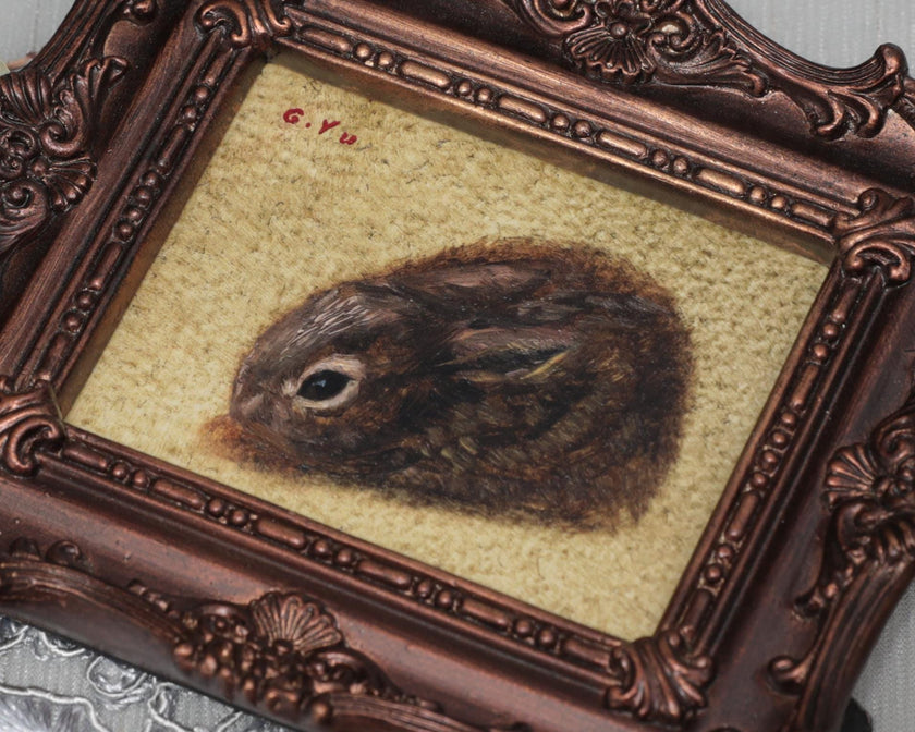 Small framed Cottontail Rabbit painting print in ornate frame, top view close-up