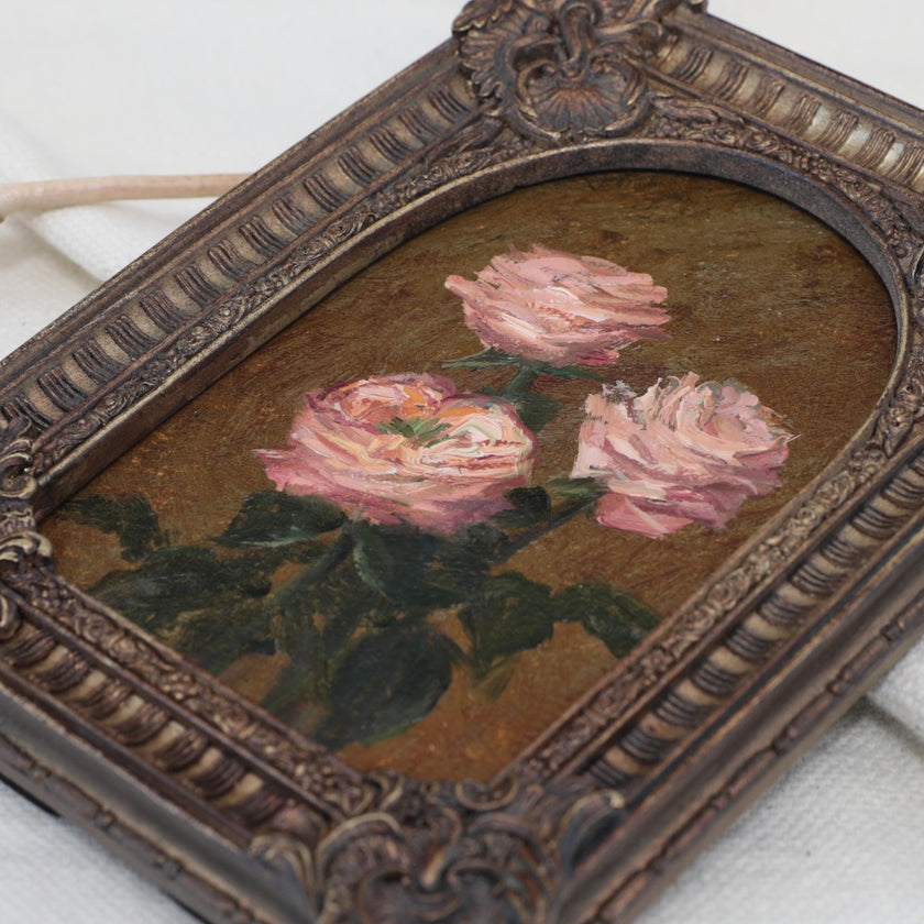 Original pink rose oil painting in arch gilt frame on cream linen, side view close up.