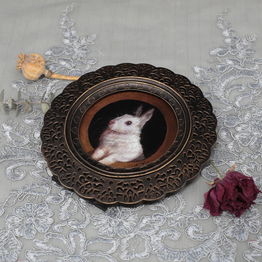 Overhead view of framed bunny art print with dried florals