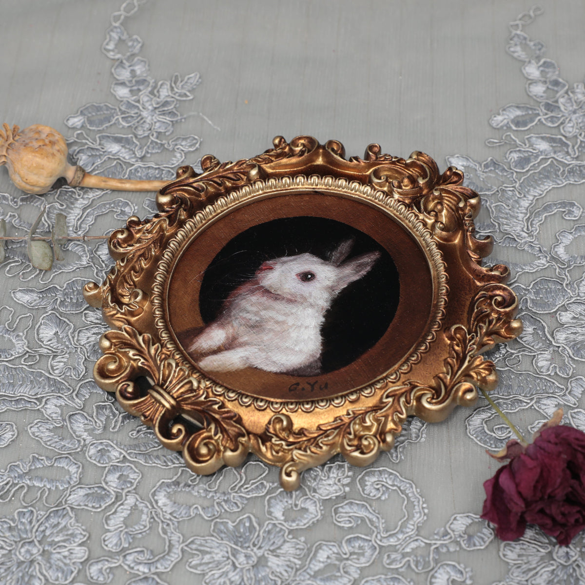 Overhead view of framed bunny art print with dried florals
