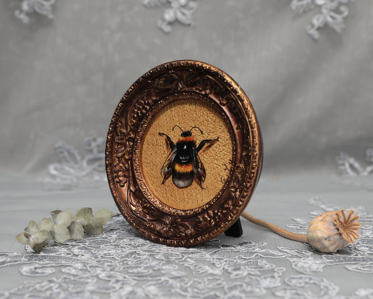 Side angle of framed bumblebee art print in carved bronze frame