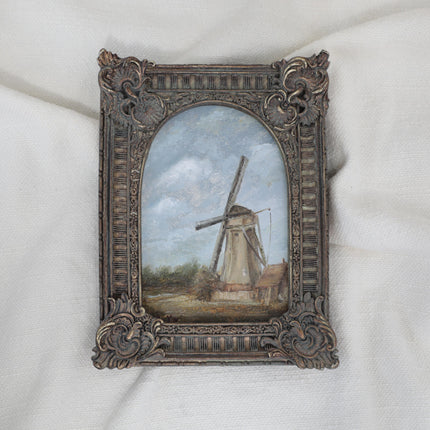 Original countryside landscape painting of a rustic windmill under a cloudy blue sky in an ornate bronze vintage-style frame