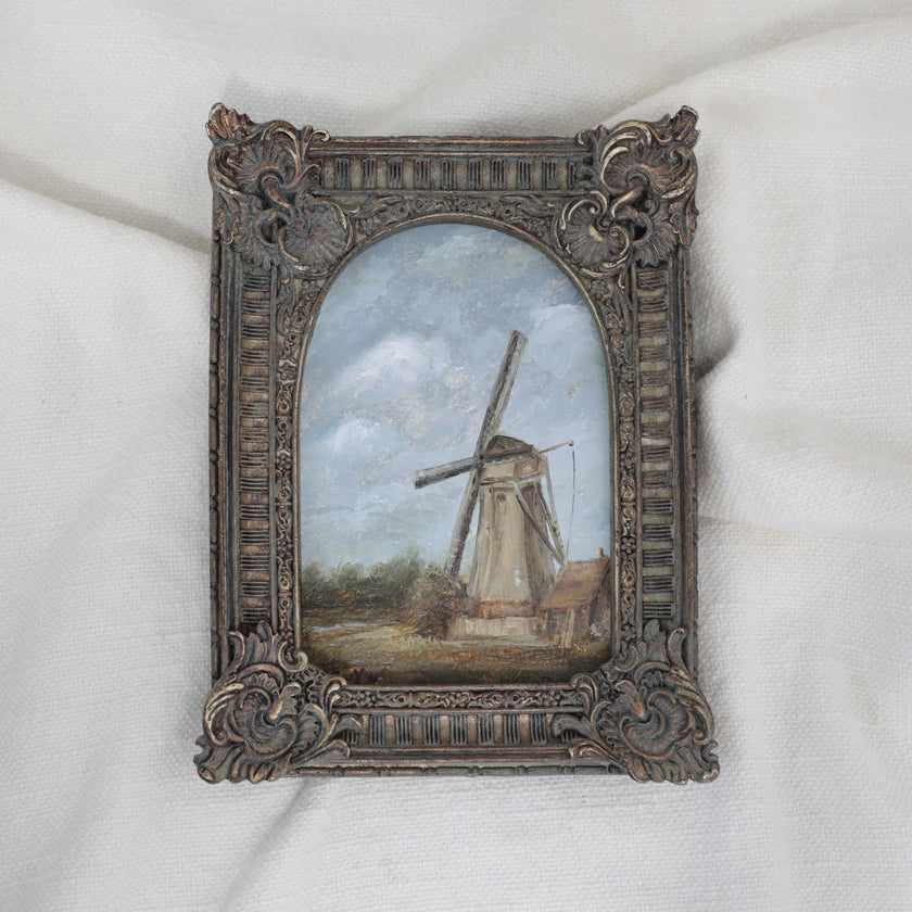 Original countryside landscape painting of a rustic windmill under a cloudy blue sky in an ornate bronze vintage-style frame