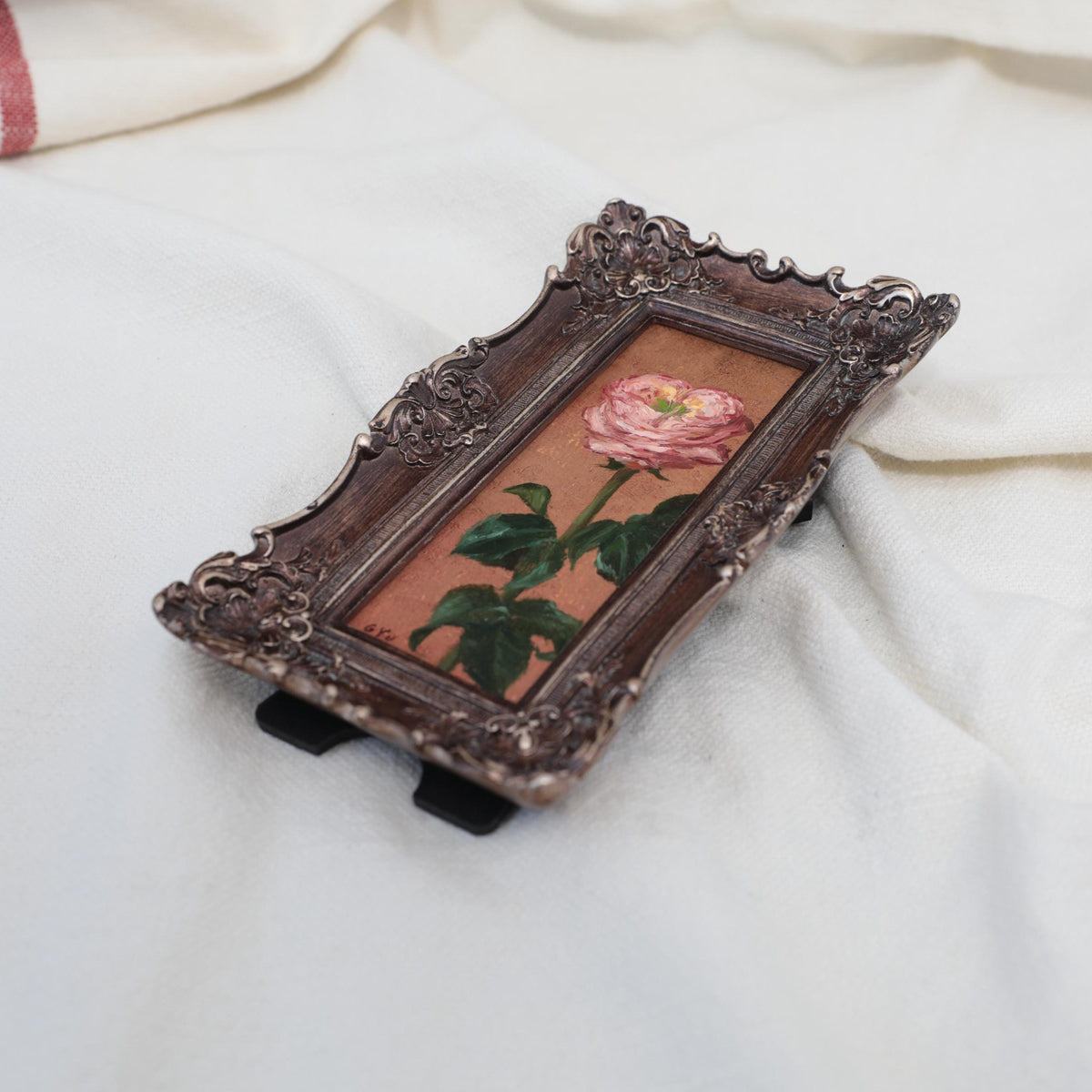 Original pink rose oil painting in an long narrow gilt frame on cream linen, side view