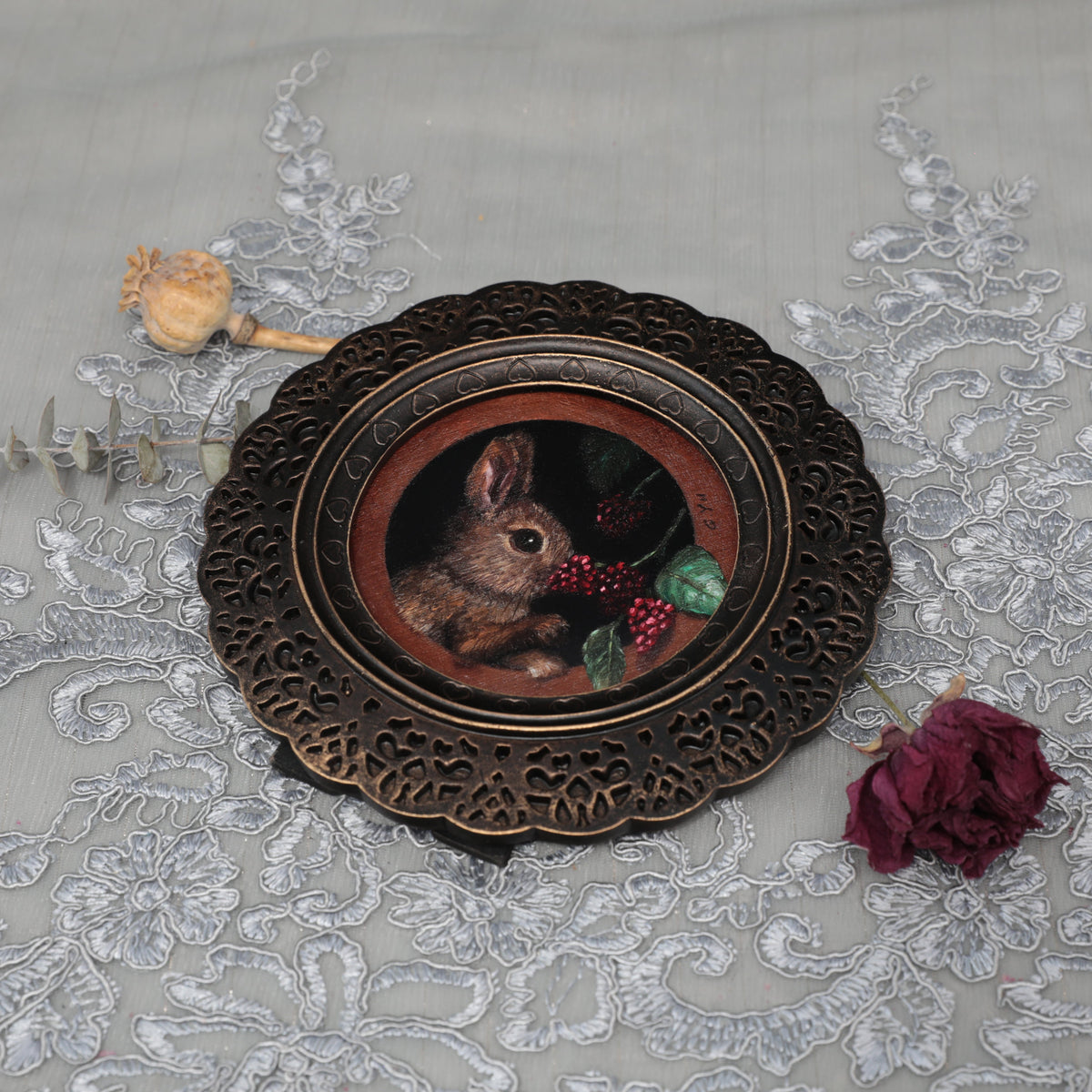Framed bunny art print in ornate bronze frame, top view