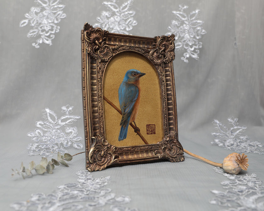 Side angle of arch-top bronze frame showing bluebird painting print