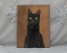 A vertical canvas painting of a black cat with yellow eyes against a warm brown background, displayed against a gray fabric backdrop with white lace decorations.