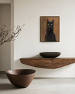 Framed custom black cat oil portrait displayed above a floating wood shelf with ceramic bowls