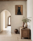Framed custom black cat oil portrait hanging in a plaster hallway near arched doorways and stoneware vases