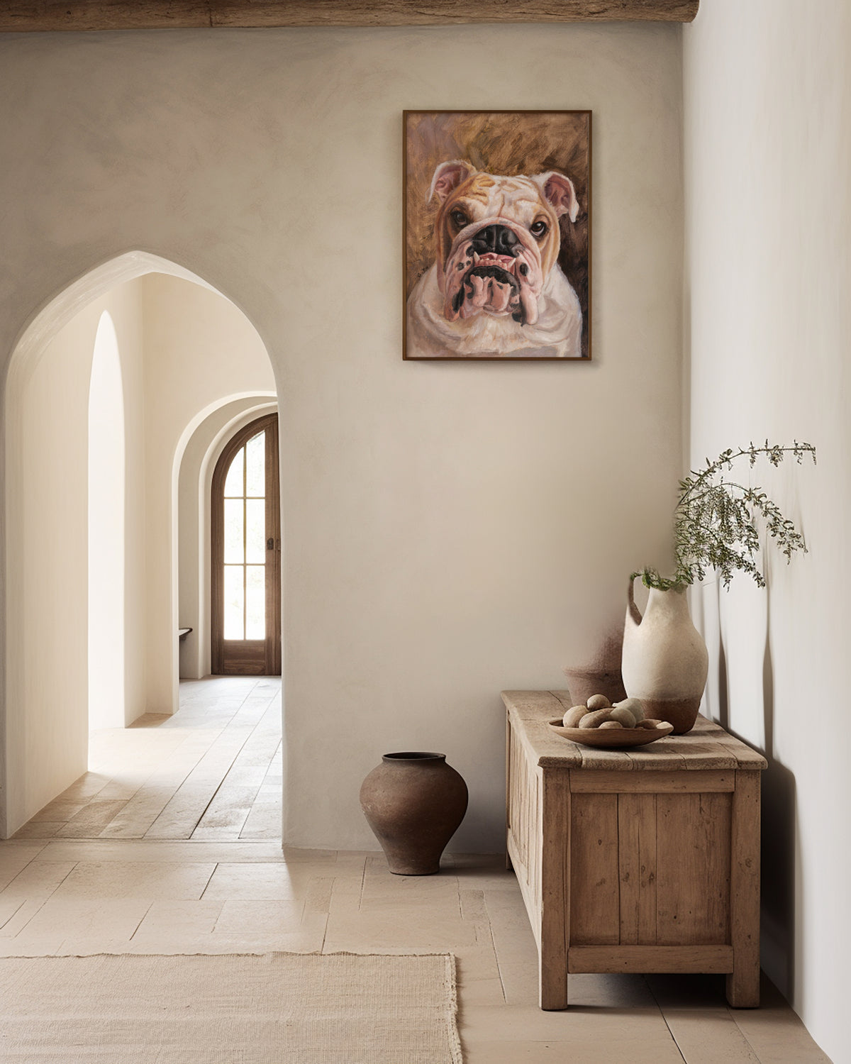 Framed custom bulldog oil portrait hanging in a plaster hallway above a wooden console table