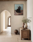 Framed French bulldog oil portrait hanging in a plaster hallway near arched doorways and stoneware vases
