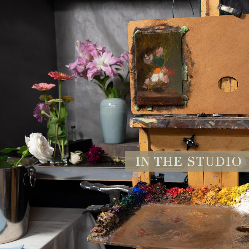 A general in-studio photoshoot of easel with still life painting in progress, flowers nearby