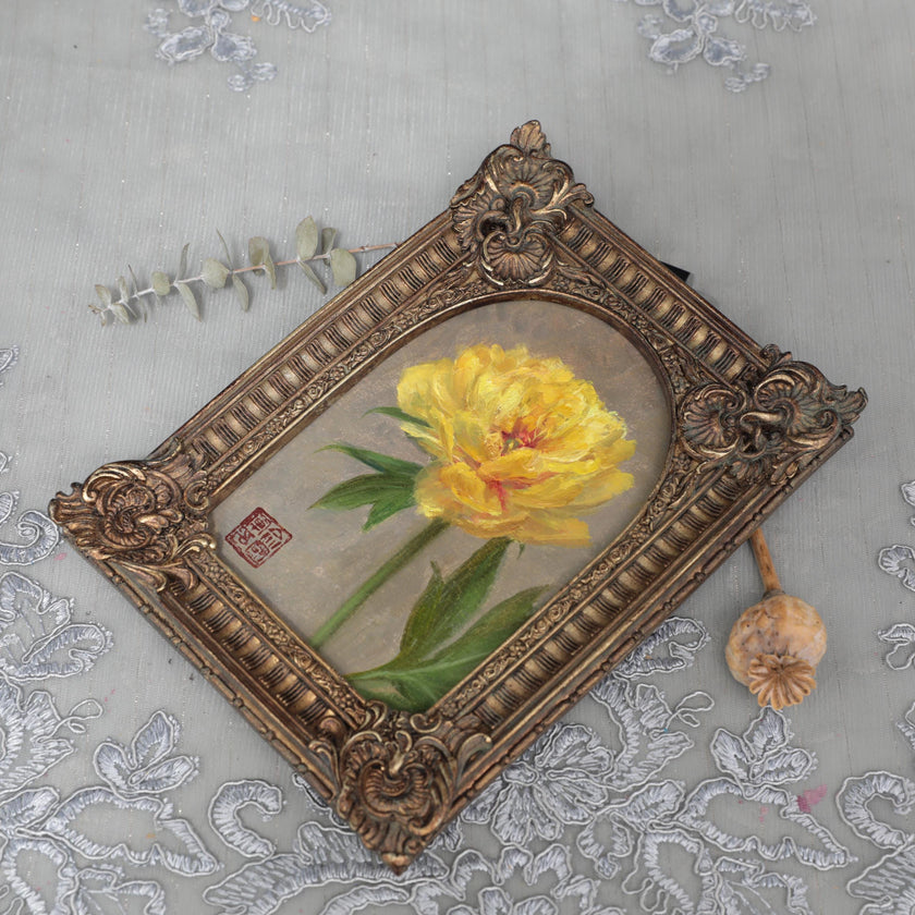 Overhead view of Bartzella peony print in arch-top frame with poppy pod