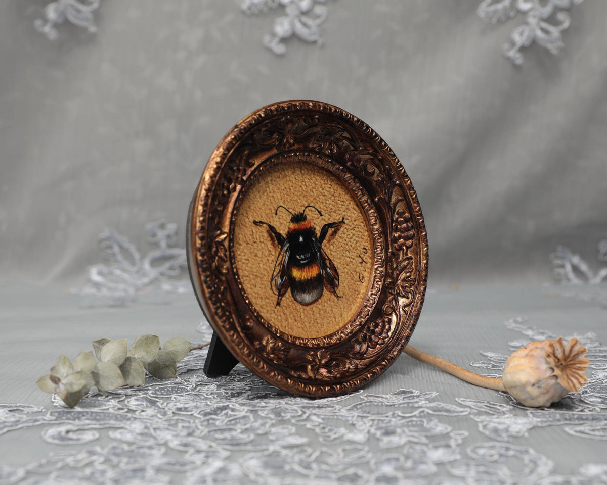 Side angle of framed bumblebee art print in carved bronze frame