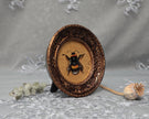 Side angle of framed bumblebee art print in carved bronze frame