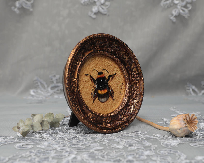 Side angle of framed bumblebee art print in carved bronze frame