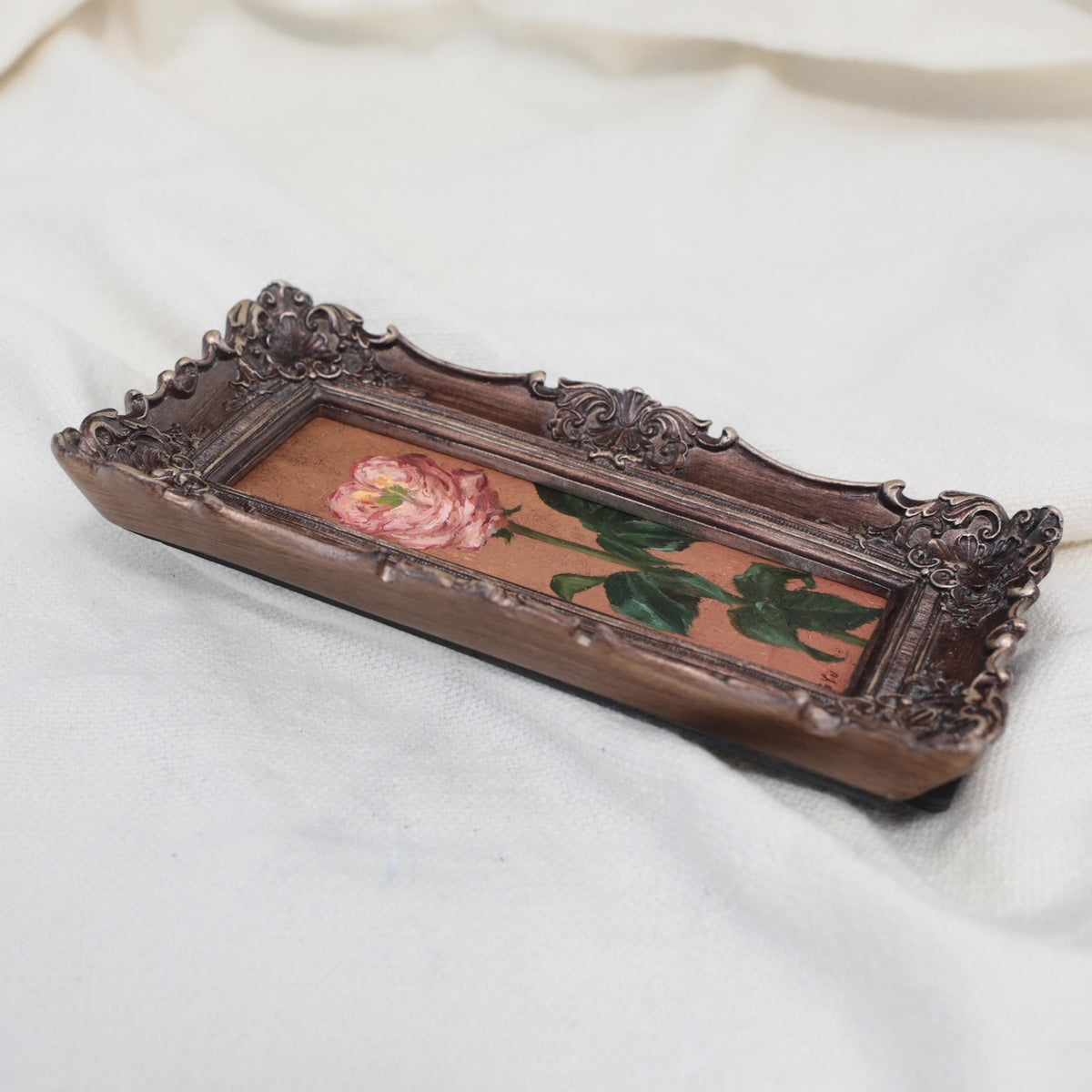 Original pink rose oil painting in an long narrow gilt frame on cream linen, side view