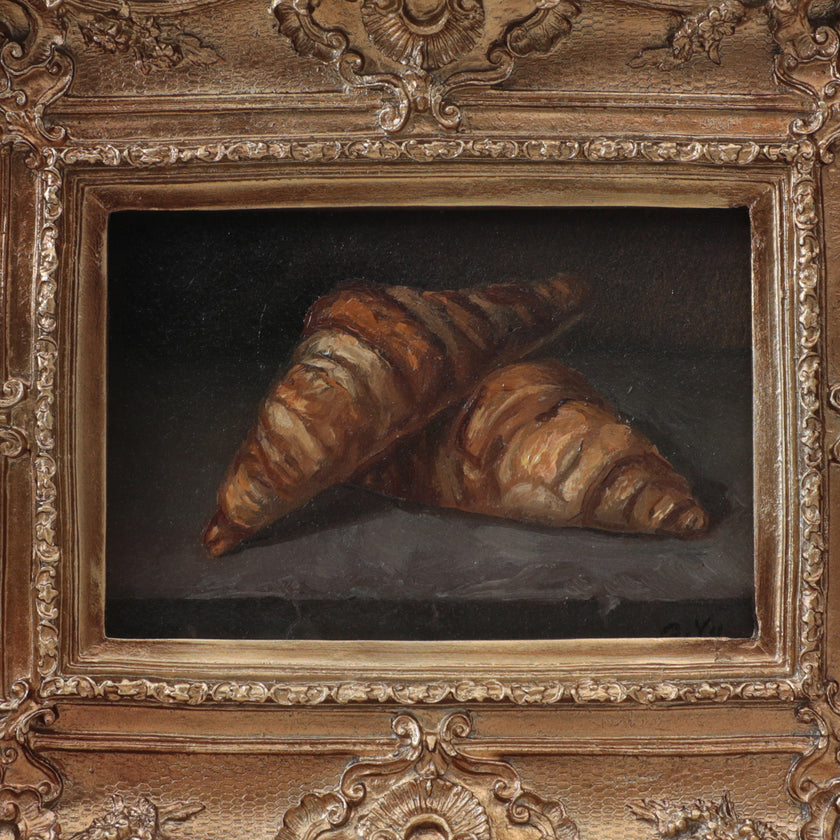 Front view of a two croissants still life oil painting in a vintage-style gilt frame