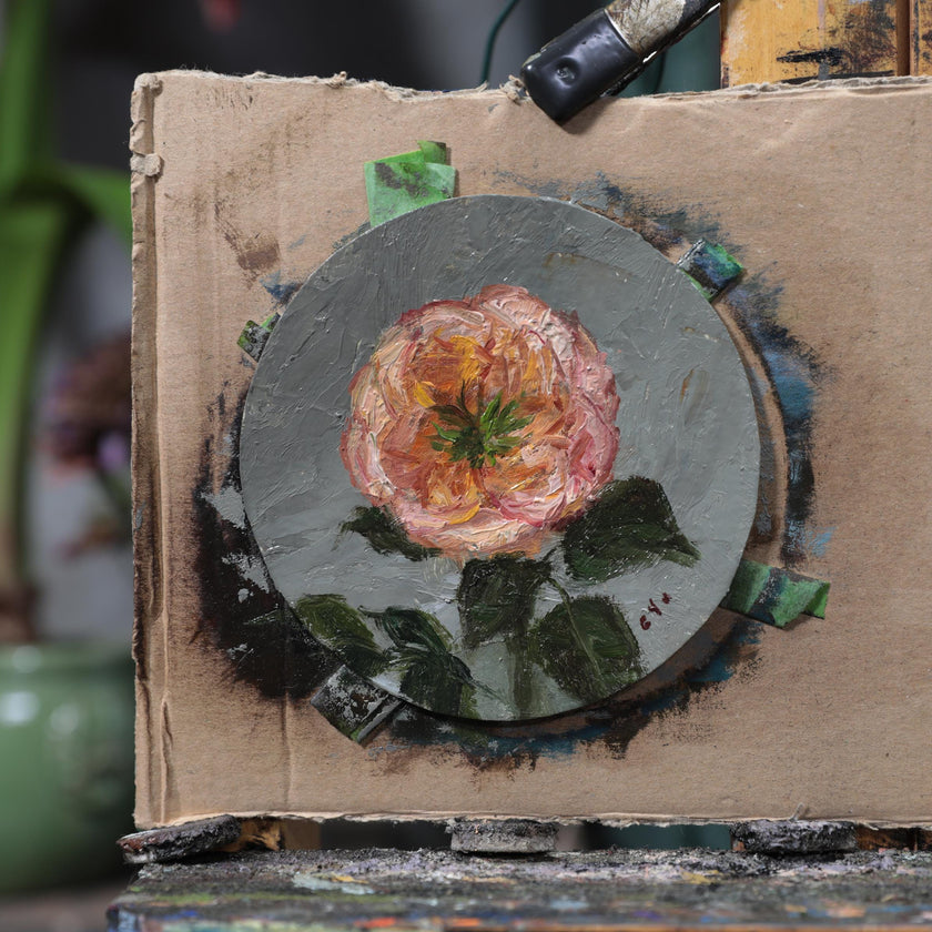 Unframed original pink rose oil painting taped to cardboard on studio easel
