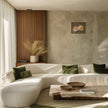 Mockup of the rose painting in a modern minimalist living room, styled with olive green throw pillows, a low wooden coffee table, and a textured beige wall.