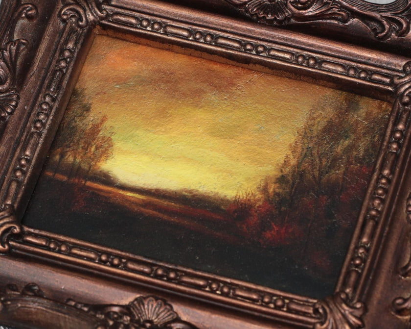 Close-up of sunset landscape oil painting print in ornate bronze frame