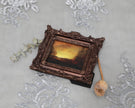 Overhead view of framed sunset landscape print with dried florals