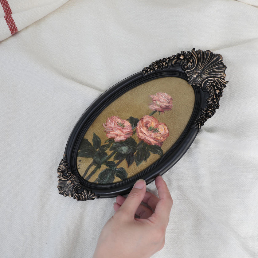Pink rose miniature oil painting in frame, with hand for scale.