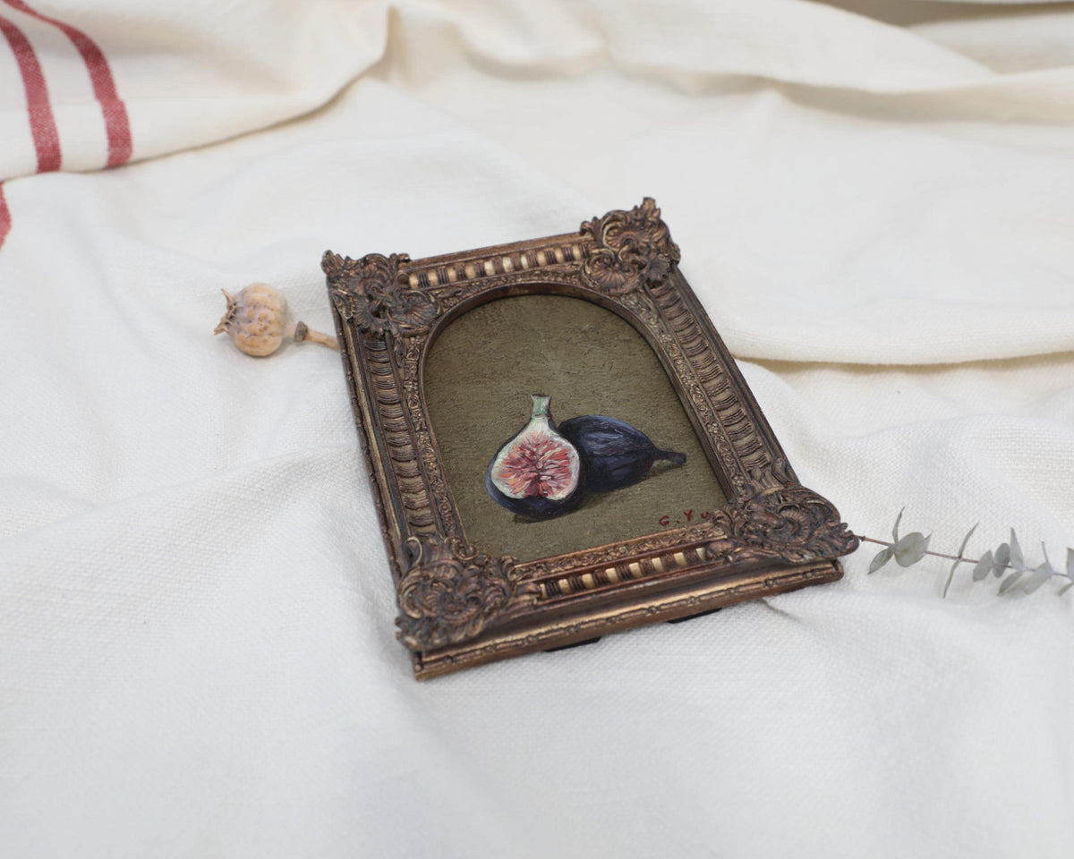 Framed fig oil painting displayed beside a dried flower, styled as small kitchen wall art