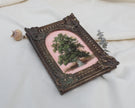 Side angle of a miniature tree landscape painting in a bronze frame with antique silver highlights