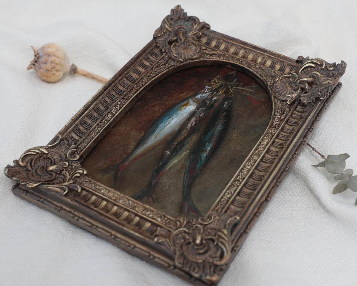 Angled close-up of a vintage-style fish oil painting in an antique bronze ornate frame